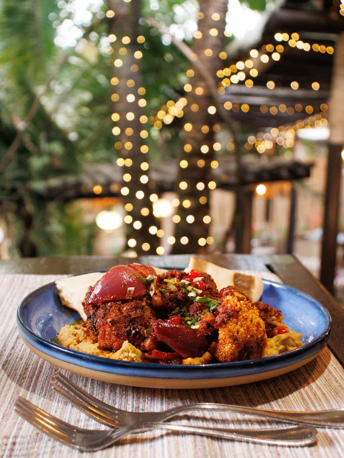 A savory Kenyan meal on a blue plate with ambient lights in the background.