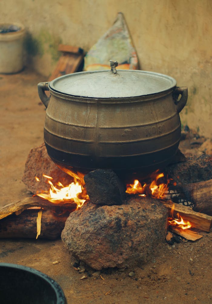 The Art of Drawing Readers In: Your attractive post title goes here A large traditional pot sits over a fire, cooking a meal in Nigeria. Rural setting.
